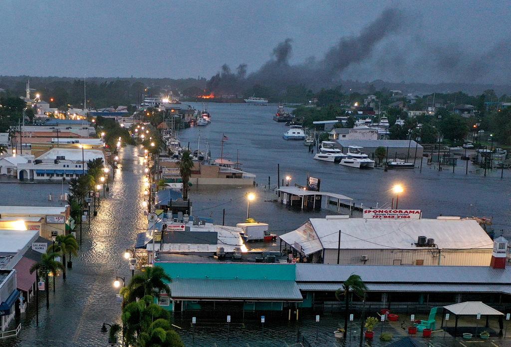 En una vista aérea, se ve un incendio mientras las aguas inundan el centro de Tarpon Springs, Florida.