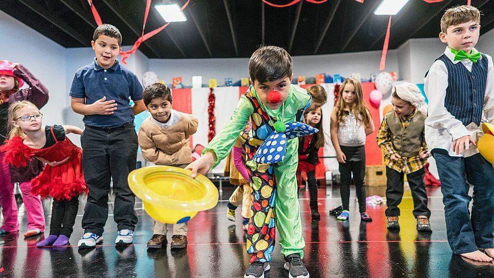 Niños saludando al público tras una obra de teatro