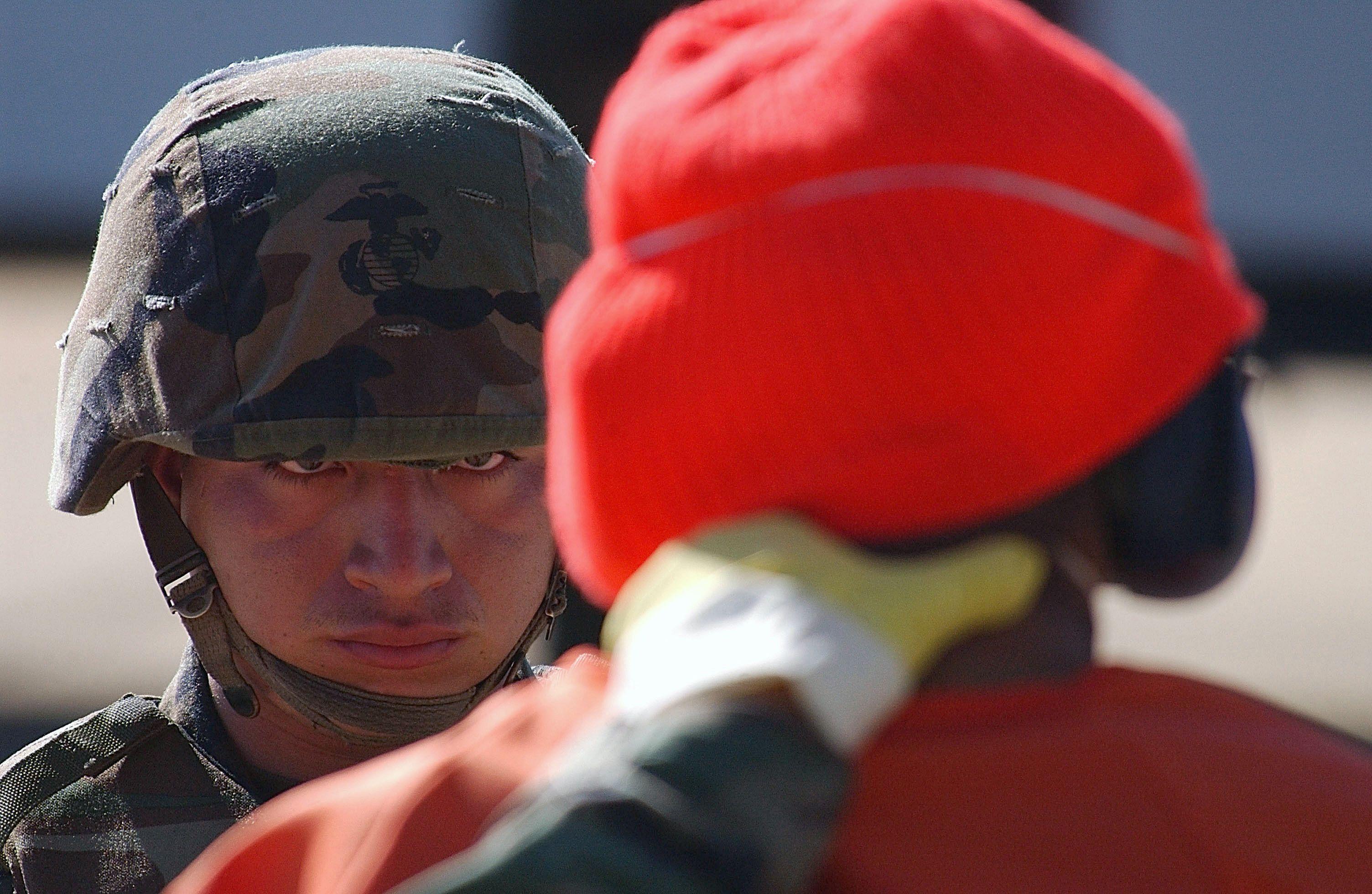 Un soldado mira a un detenido.