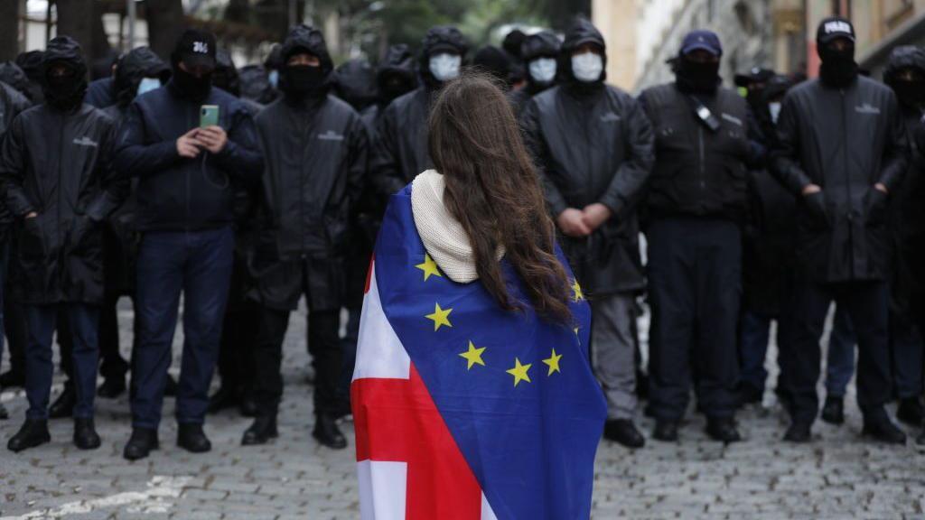 Manifestante en Georgia envuelta en banderas