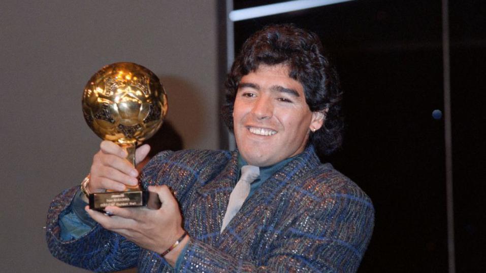 Maradona muestra sonriente su Balón de Oro. 