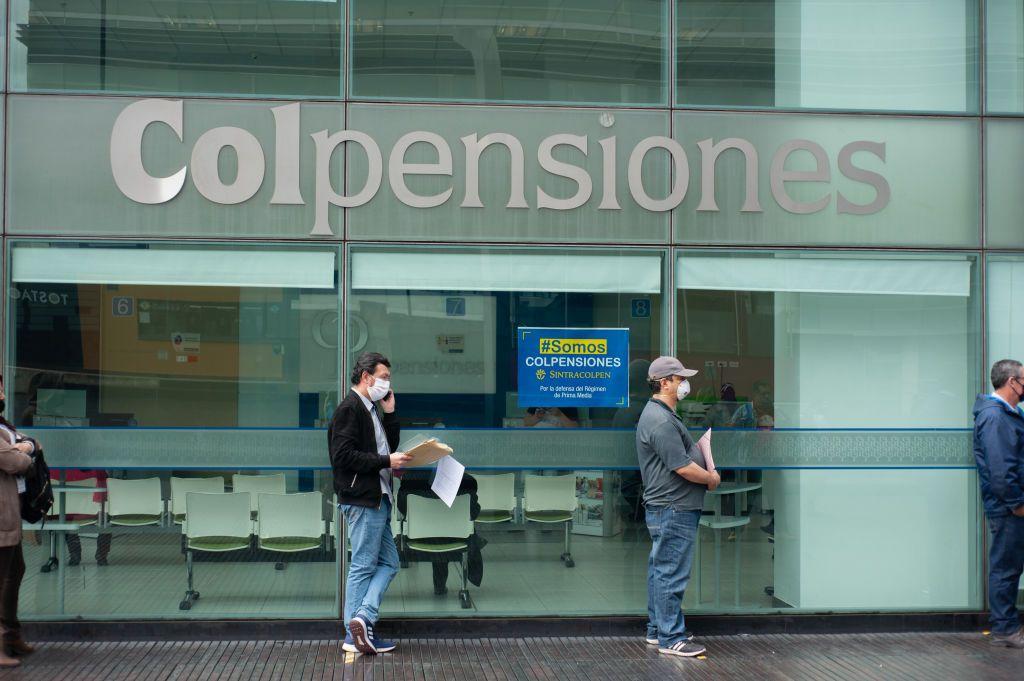 Personas frente a una sede de Colpensiones en Colombia. 