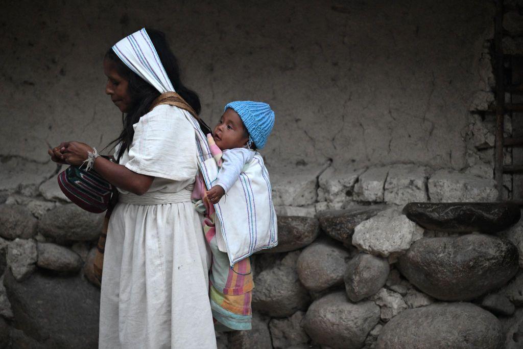 Una mujer indígena lleva a su bebé en su espalda en la Sierra Nevada de Santa Marta en Colombia. 