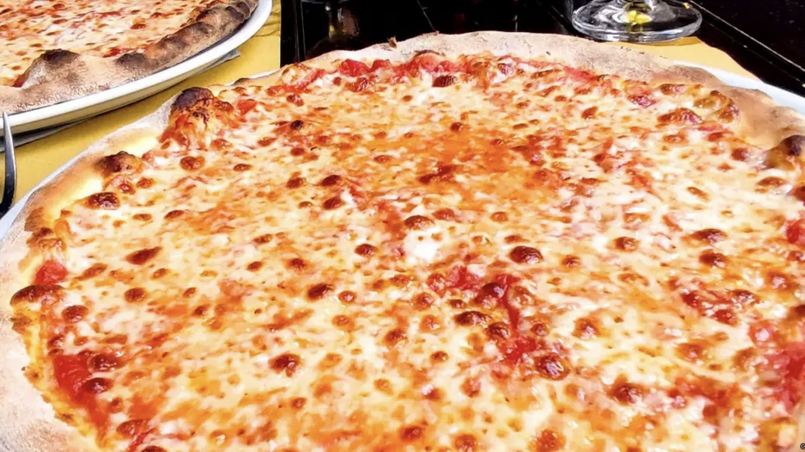 Una pizza recién hecha sobre la mesa, lista para ser disfrutada, combinando ingredientes irresistibles que deleitan los sentidos.
