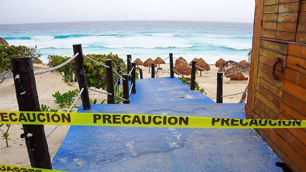 Playa cerrada con una cinta que dice "precaución"