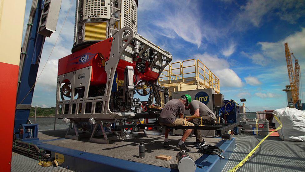 Hombres terminando de afinar detalles en los robots que sumergirán en el mar.