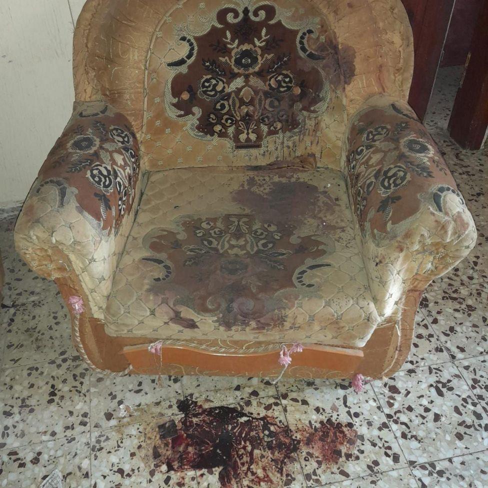 Sillón con manchas de sangre en el piso