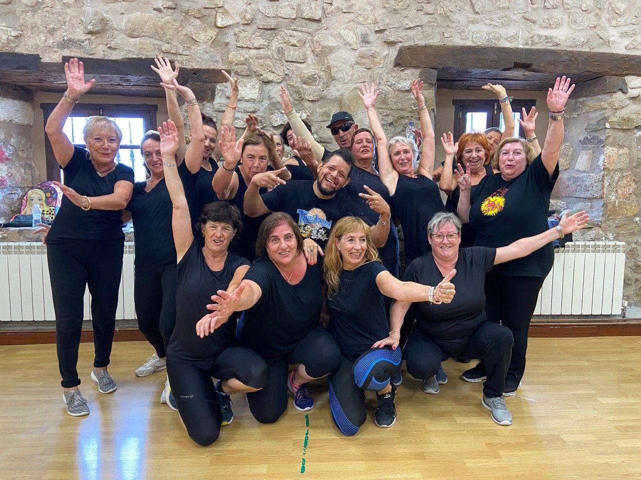 Grupo de personas en ropa deportiva en un gimnasio.