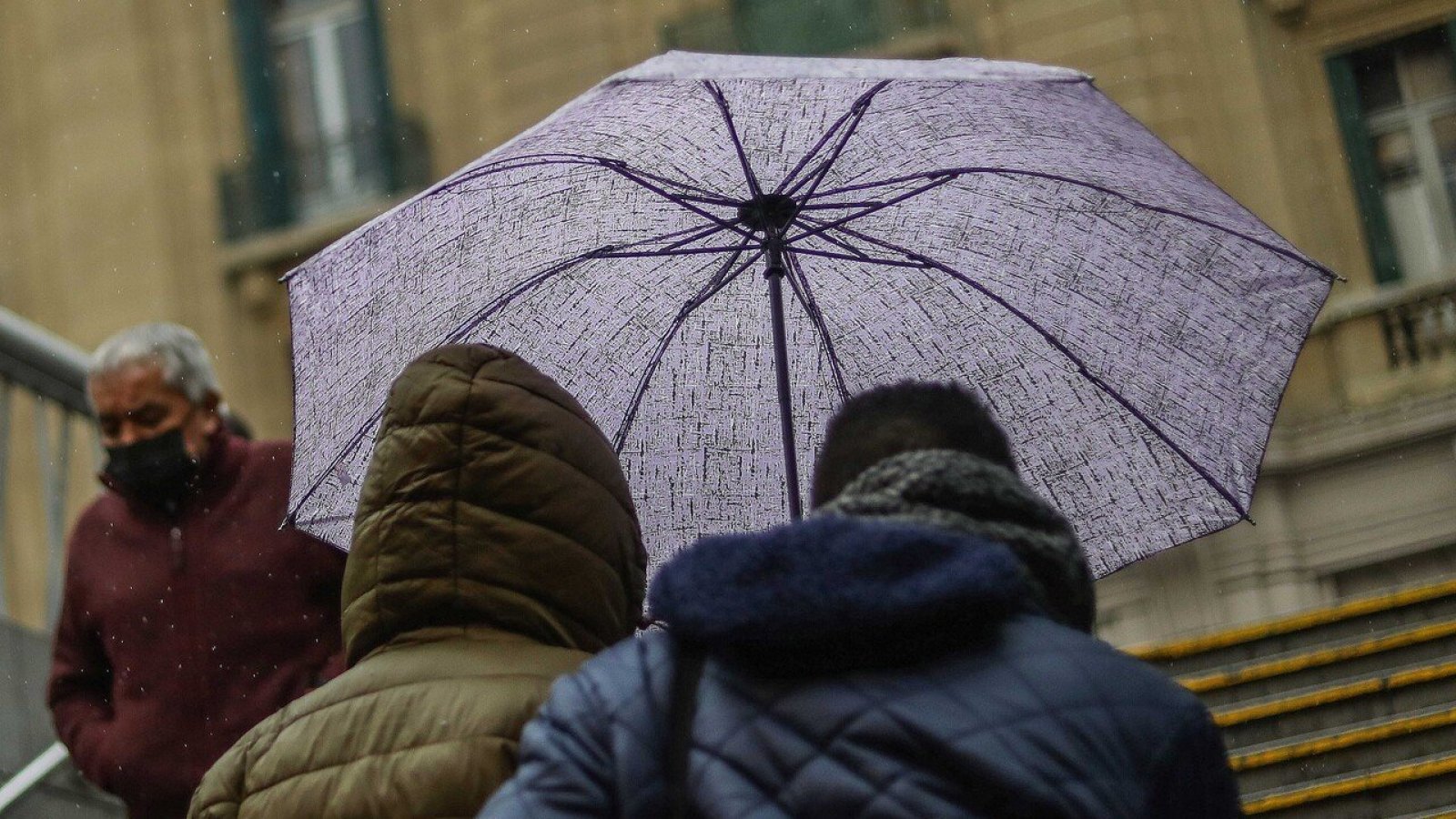 Personas bajo la lluvia con paraguas.