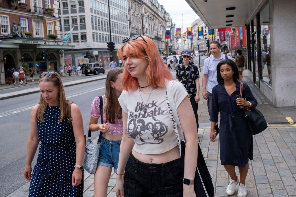 Una joven mujer camina en las calles de Londres con una playera de Black Sabbath