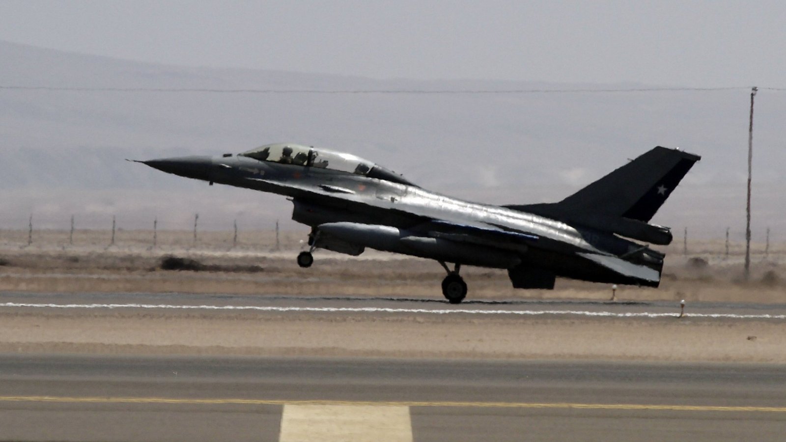 Imagen de archivo de la ceremonia de inauguración de la Fidae, mostrando un piloto de la FACh abordando un avión militar y saludando a la cámara.