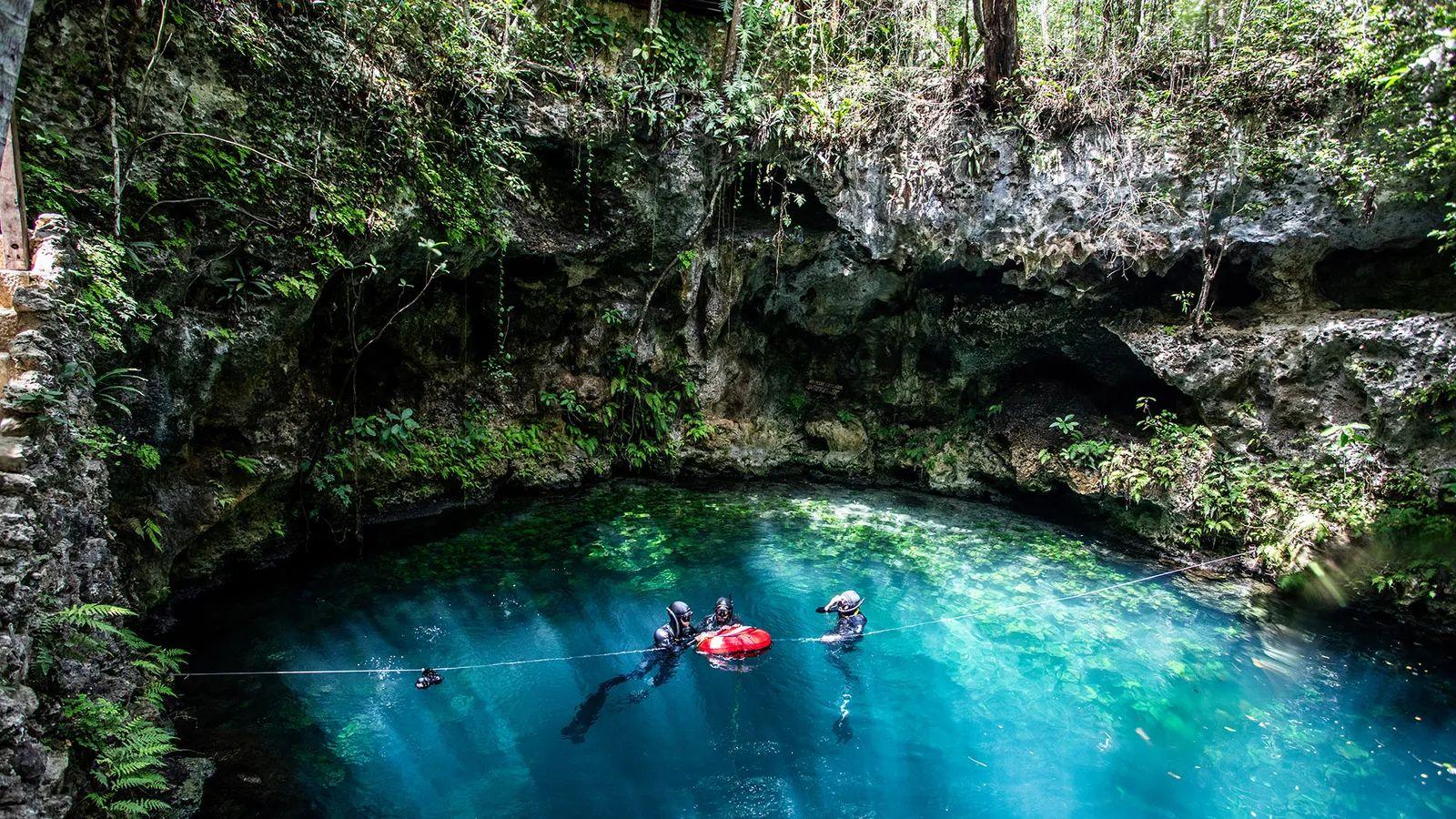 3 buceadores en la superficie de un cenote