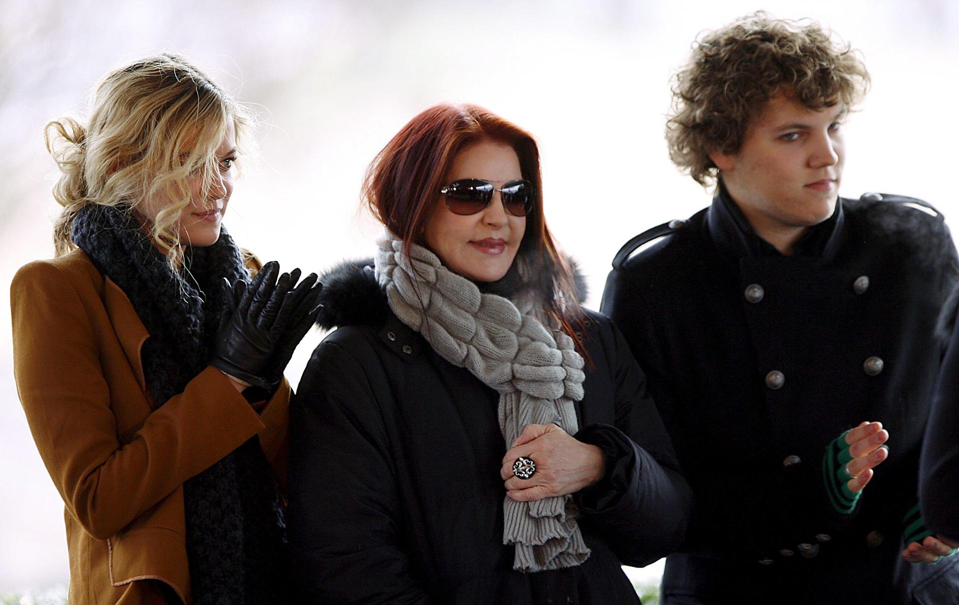 Priscilla Presley (c), mientras acompaña a sus nietos Riley Keough (i) y Benjamin Keough (d)