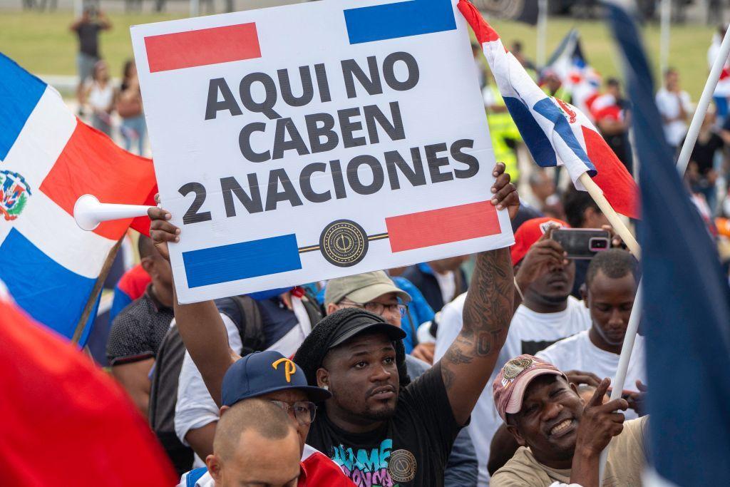 Un hombre sostiene una pancarta en la que se lee "Aquí no caben dos naciones" durante una manifestación en Santo Domingo, República Dominicana, el 5 de octubre de 2024.