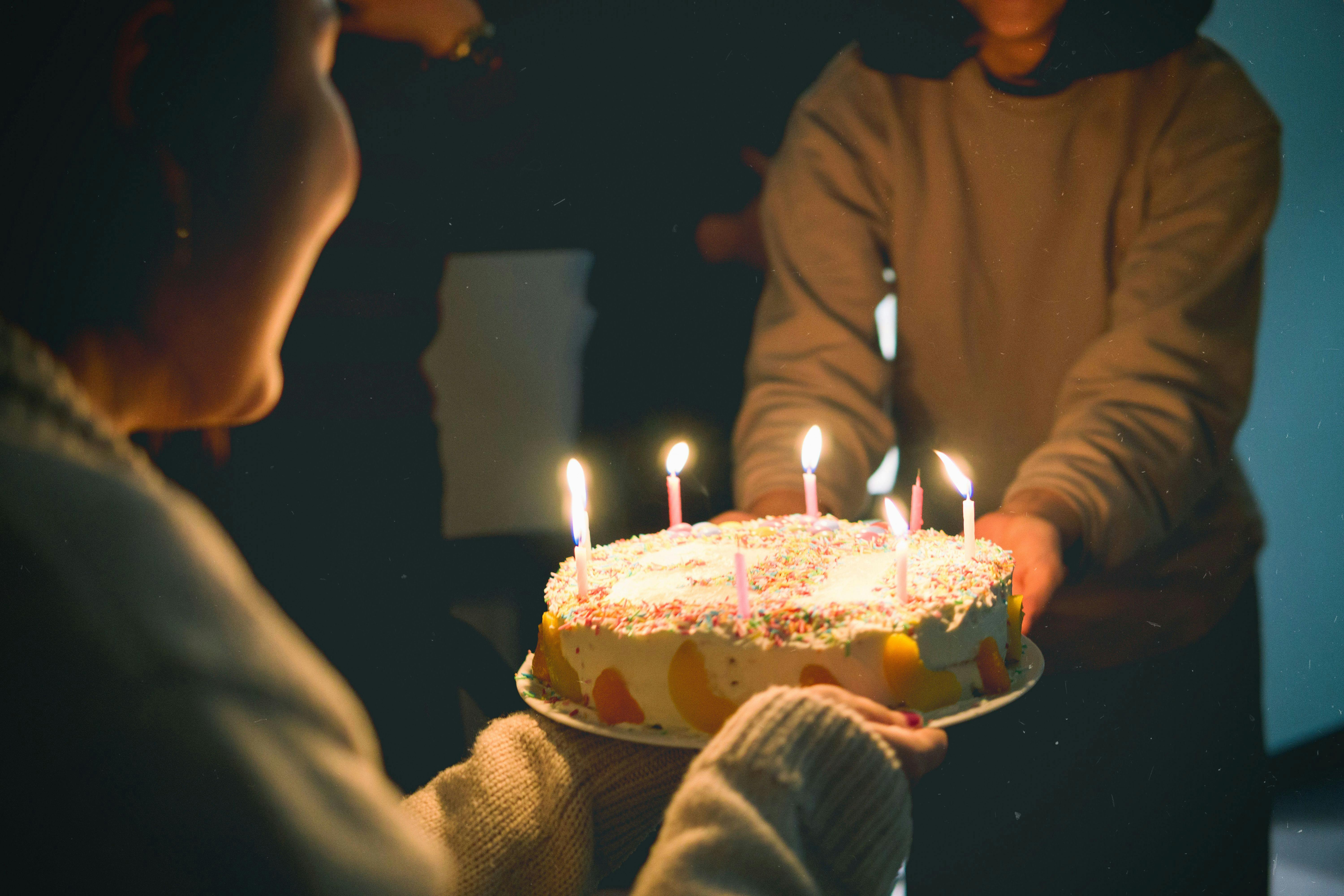 Mujer sujetando pastel de cumpleaños