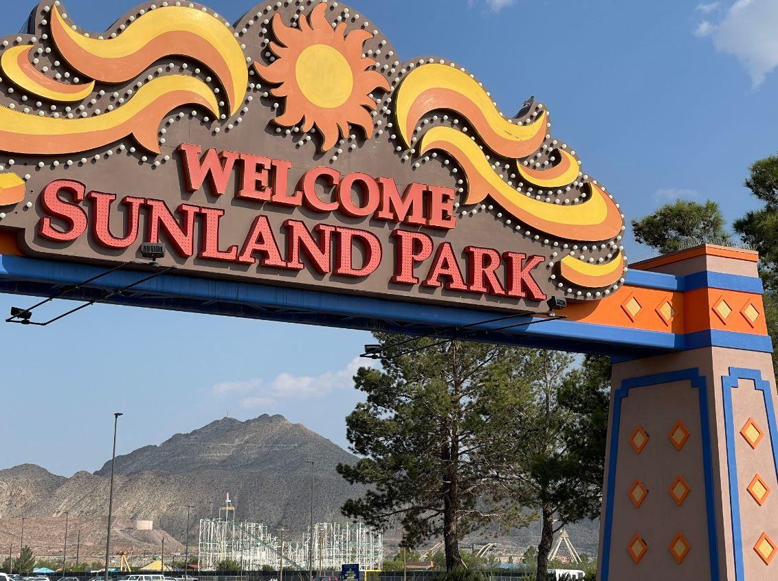 Cartel que reza "Bienvenidos a Sunland Park" en el parking del casino-hipódromo, con el parque de atracciones y el monte Cristo Rey de fondo, en Sunland Park, Nuevo México, el 25 de julio de 2024.