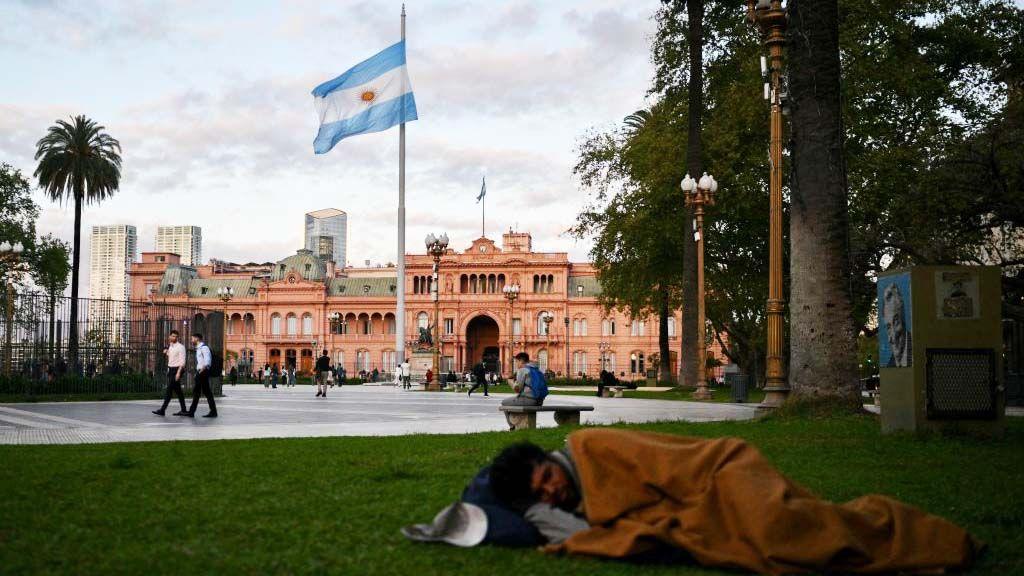 Un hombre durmiendo en la Plaza de Mayo, frente a la Casa Rosada.