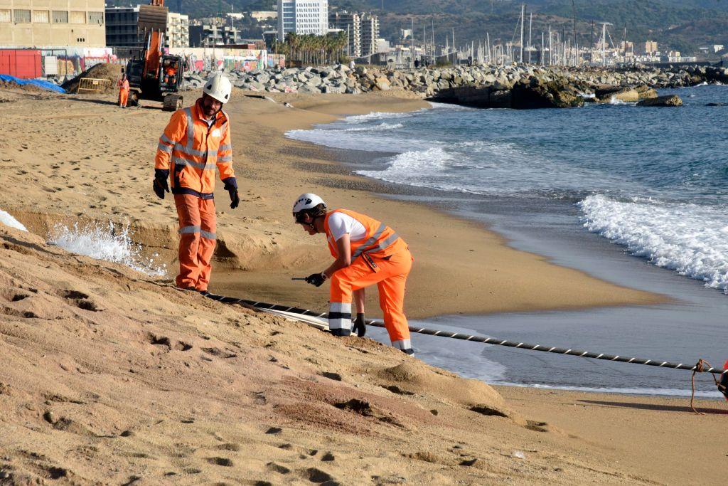 Técnicos revisando un cable submarino que llegó a la orilla