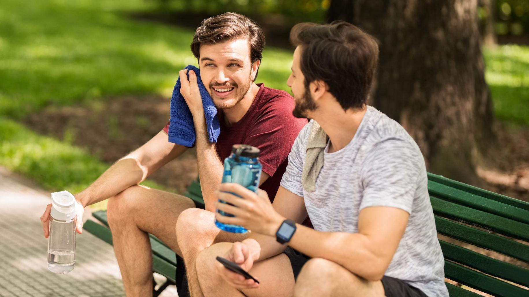 Dos hombres descansando tras una caminata en el parque