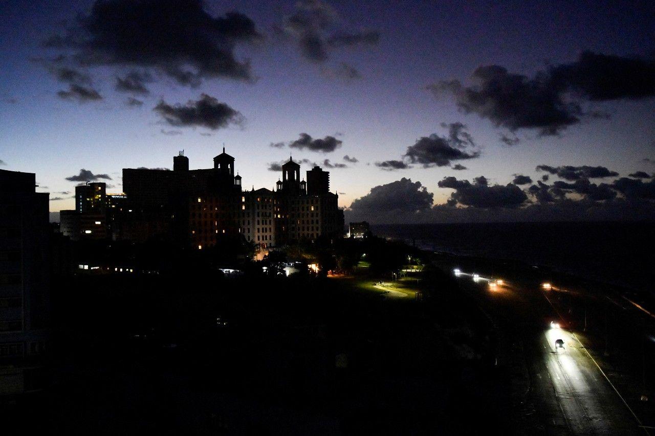 Los automóviles pasan frente al Hotel Nacional y por el malecón de La Habana con todo a oscuras. 