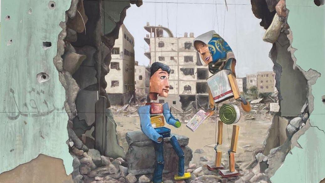 Un mural que representa los títeres construidos por Mahdy Krira con latas entre un muro bombardeado en Gaza