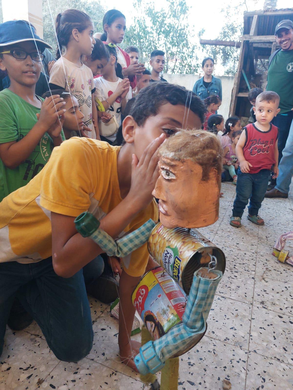 Un niño interactúa con un títere durante una función en Gaza