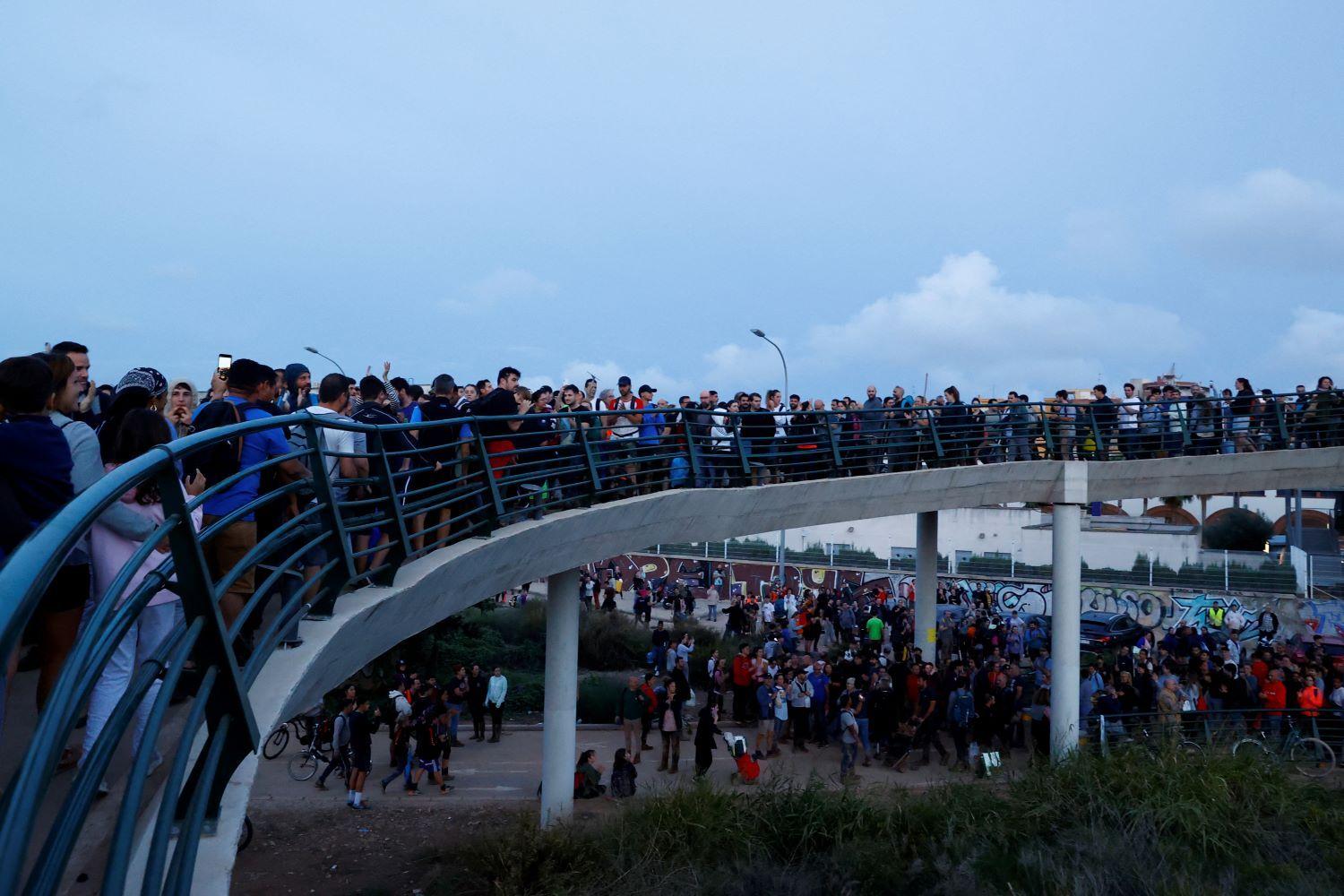 Personas cruzan los puentes que unen a la ciudad de valencia con las comunidades afectadas por la dana