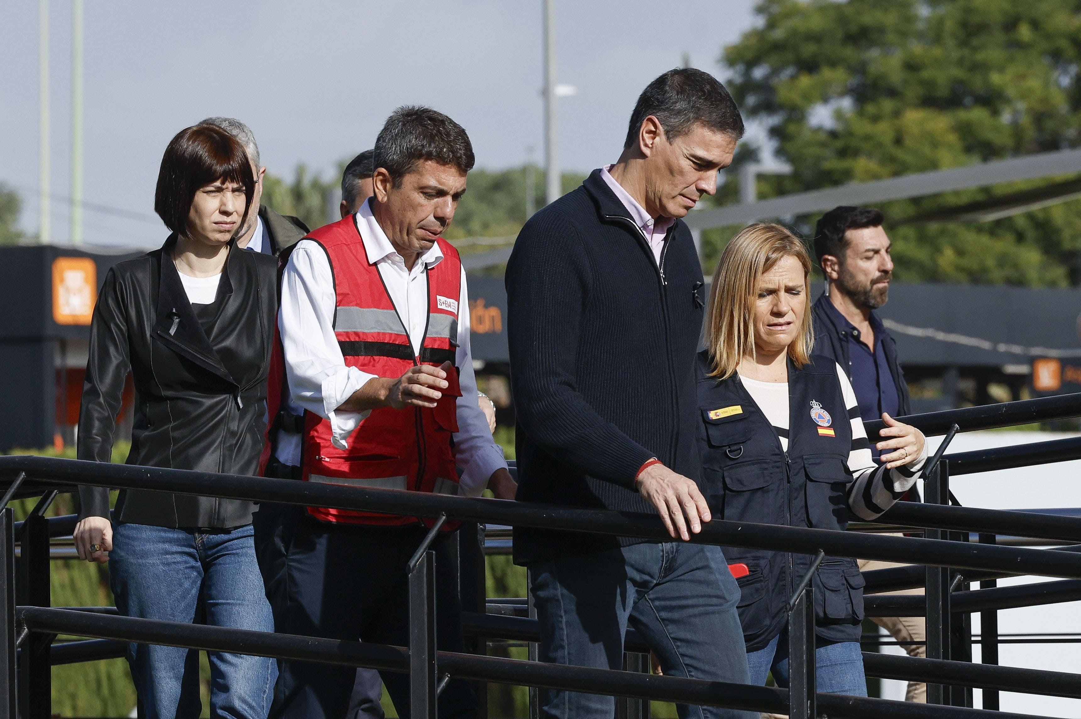 El presidente del gobierno español, Pedro Sánchez, seguido de Carlos Mazón, presidente del gobierno regional de la Comunidad Valenciana, caminan cariacontecidos en la visita de Sánchez a Valencia tras la tragedia. 