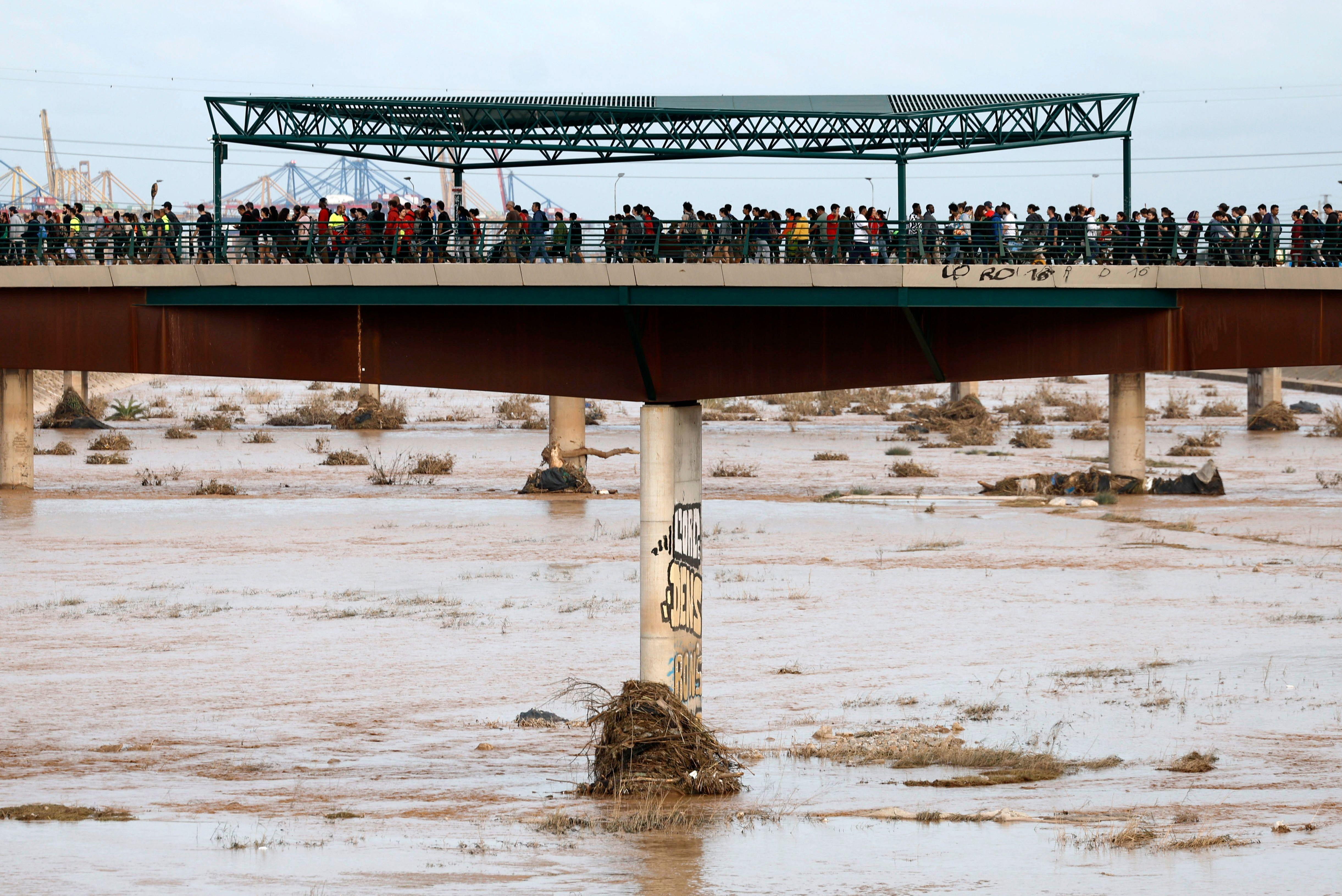 Personas cruzan los puentes que unen a la ciudad de valencia con las comunidades afectadas por la dana