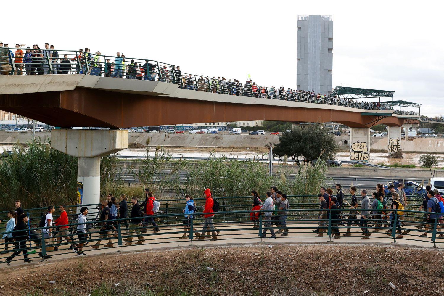 Personas cruzan los puentes que unen a la ciudad de valencia con las comunidades afectadas por la dana