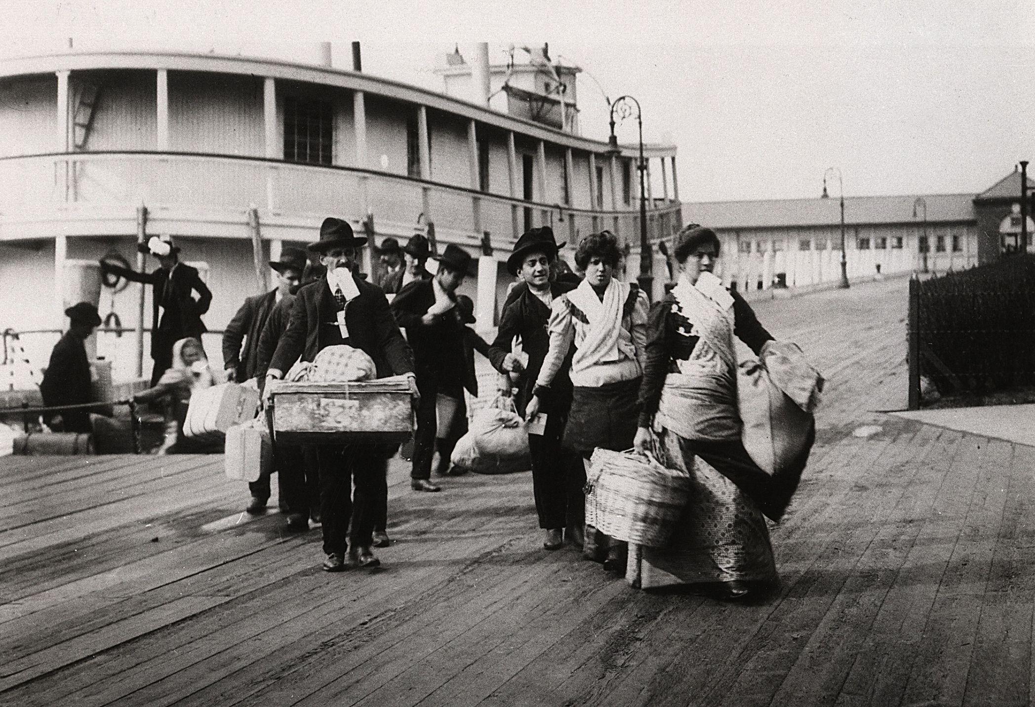 Inmigrantes llegando a Ellis Island, New York, alrededor de 1900.
Ellis Island fue el principal punto de inmigración de Estados Unidos entre 1892 y 1943, y recibió a unos 20 millones de inmigrantes. (Fotografía de Ann Ronan Pictures/Print Collector/Getty Images)

