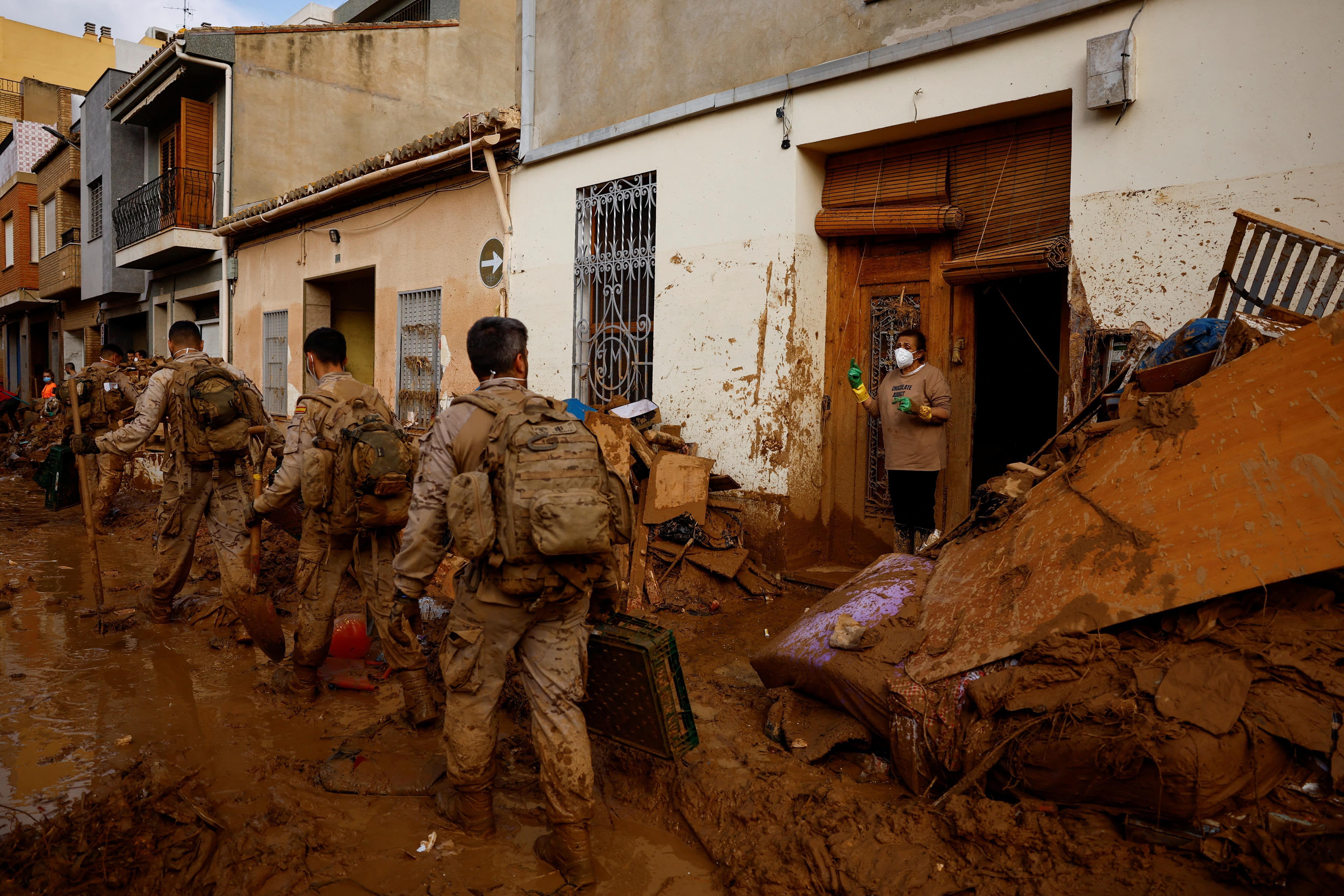 Militares cubiertos de barro caminan por una de las poblaciones afectadas. 