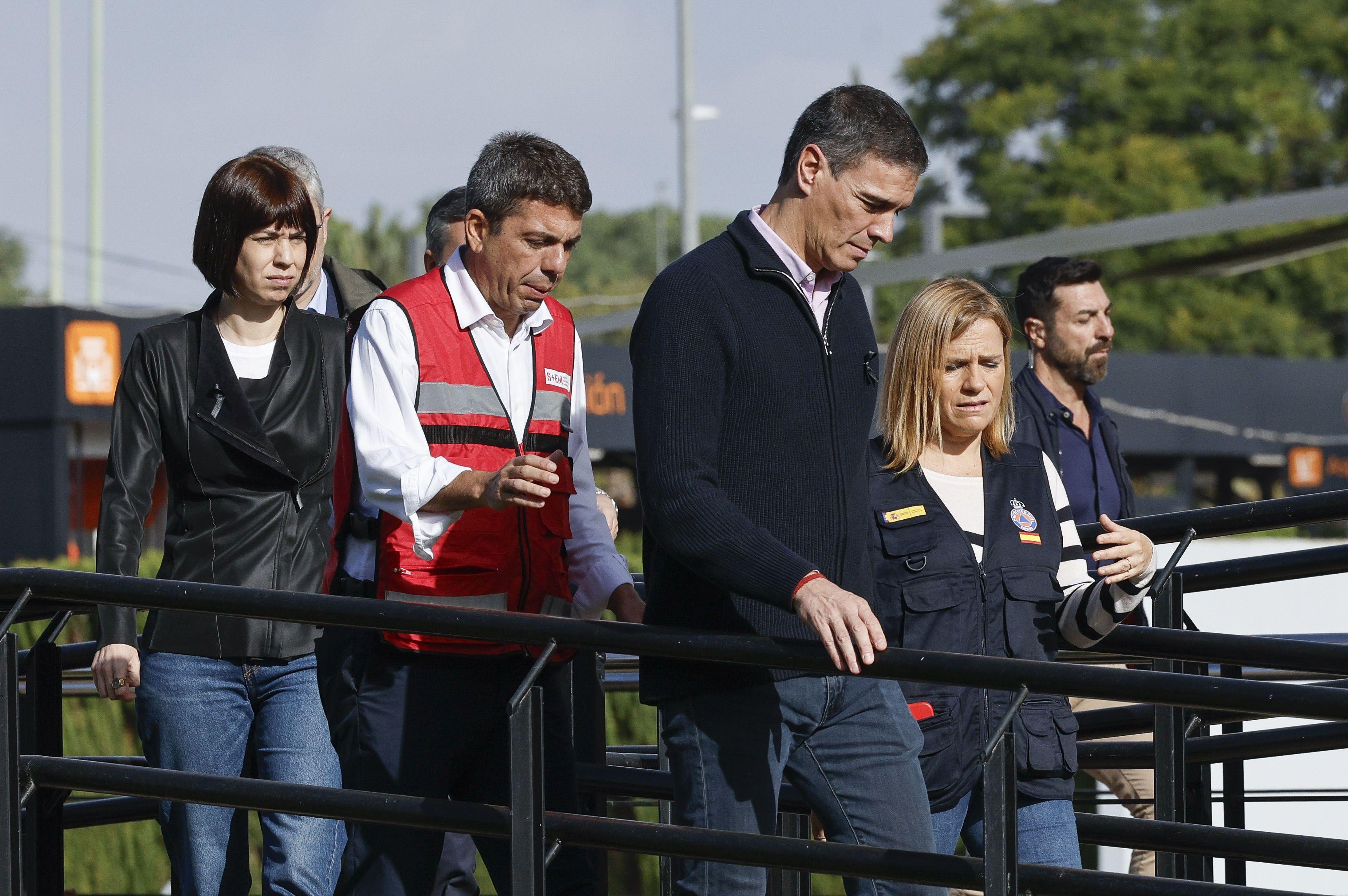 El presidente del gobierno español, Pedro Sánchez, camina seguido de Carlos Mazón, presidente del gobierno regional de la Comunidad Valenciana, y otras autoridades. 