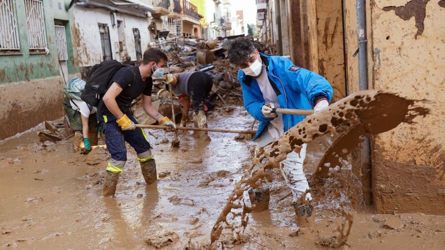 Personas quitando barro