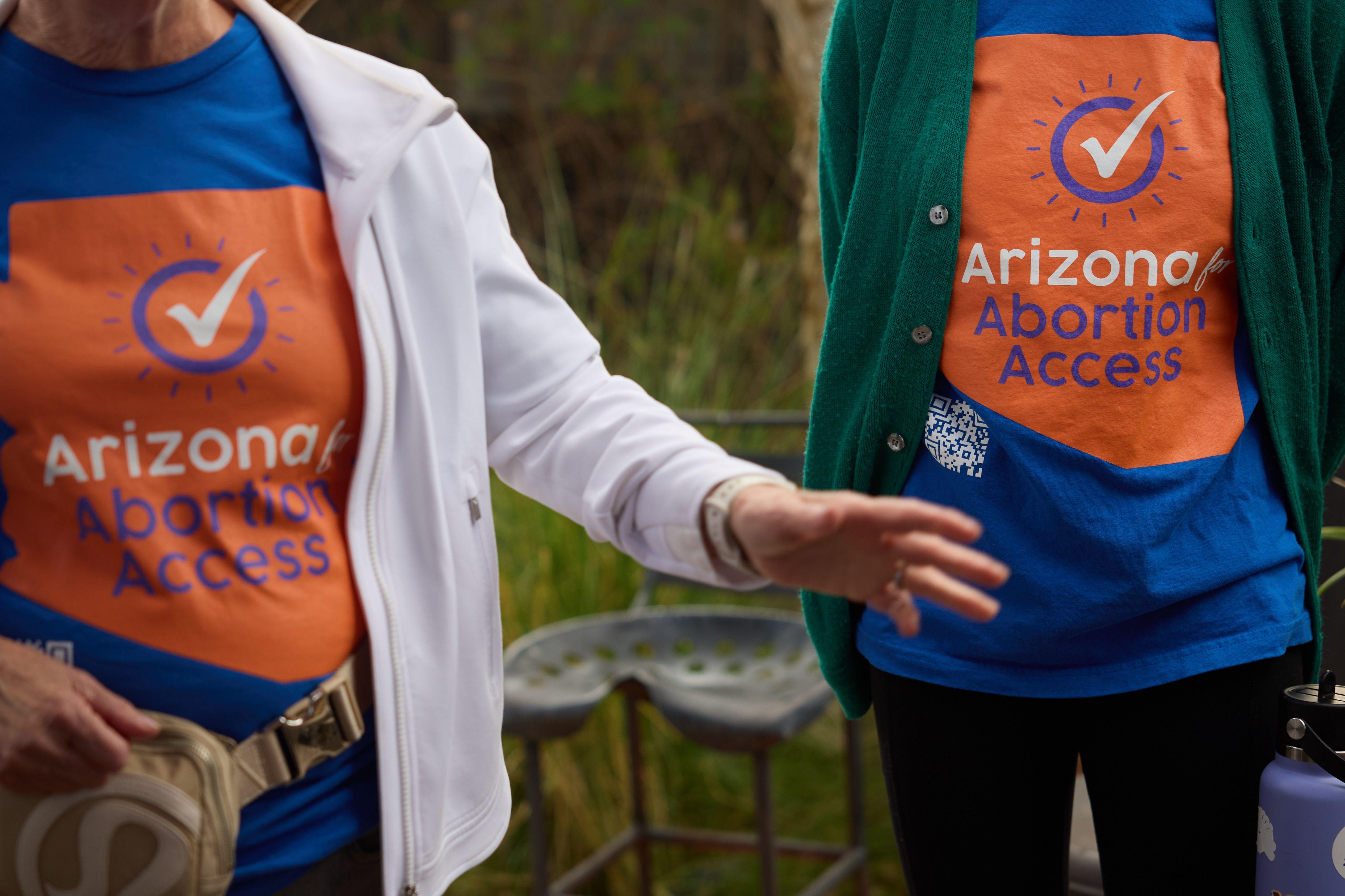 Dos personas con camisetas a favor del acceso al aborto en Arizona.