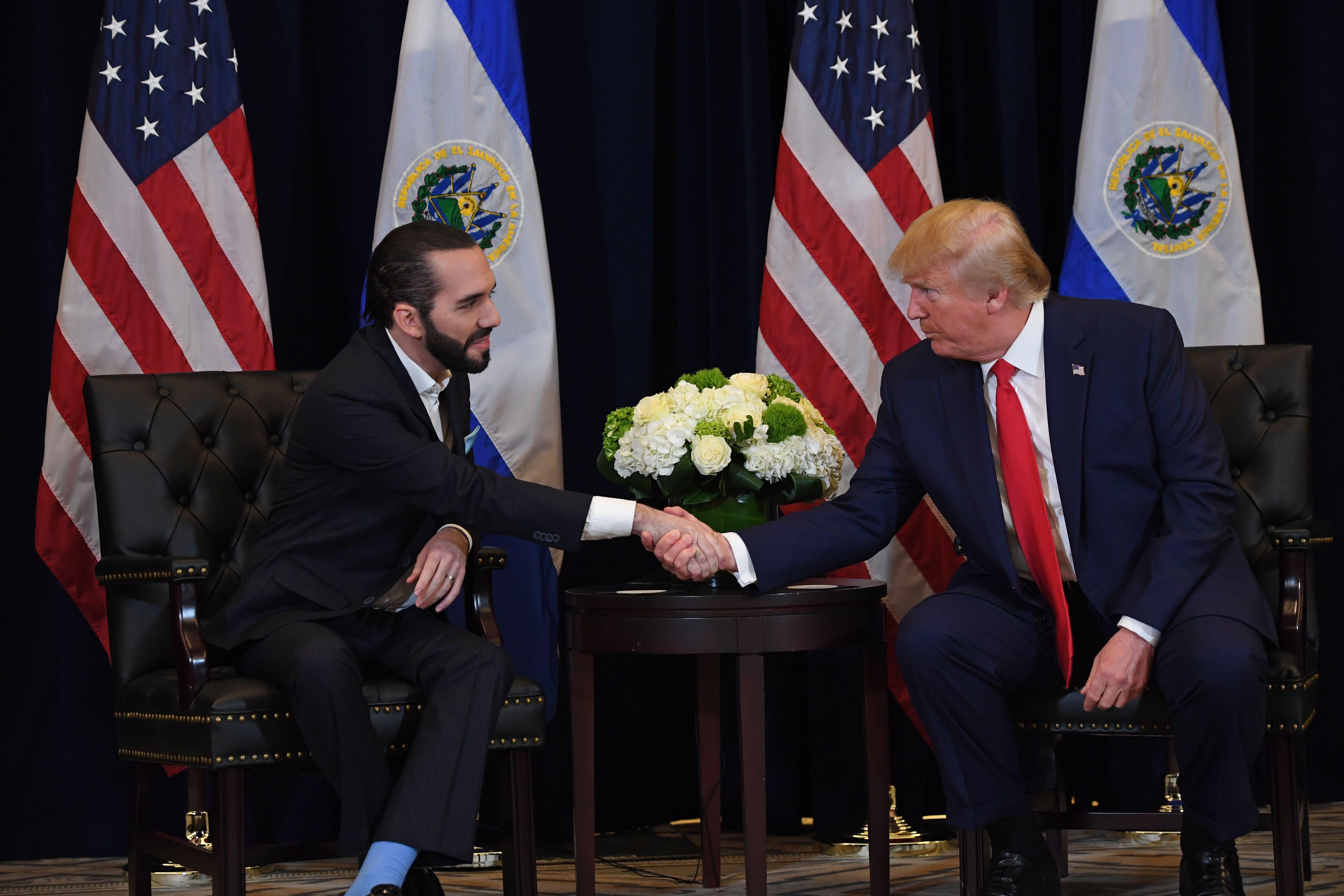 Nayib Bukele y Donald Trump estrechan manos con las banderas de sus países detrás