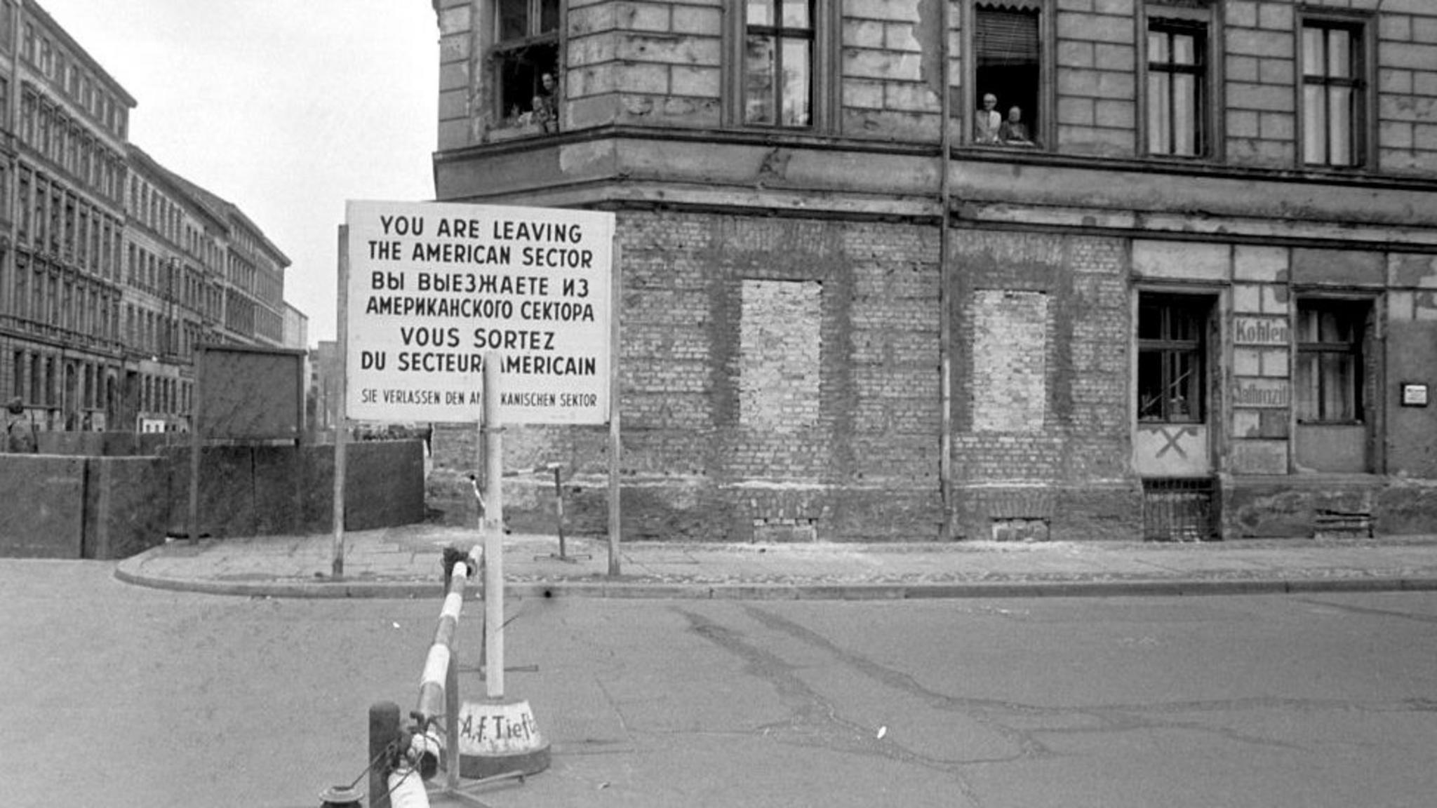 Una calle en Berlín con una valla que avisa en cuatro idiomas que se está abandondando el sector estadounidense