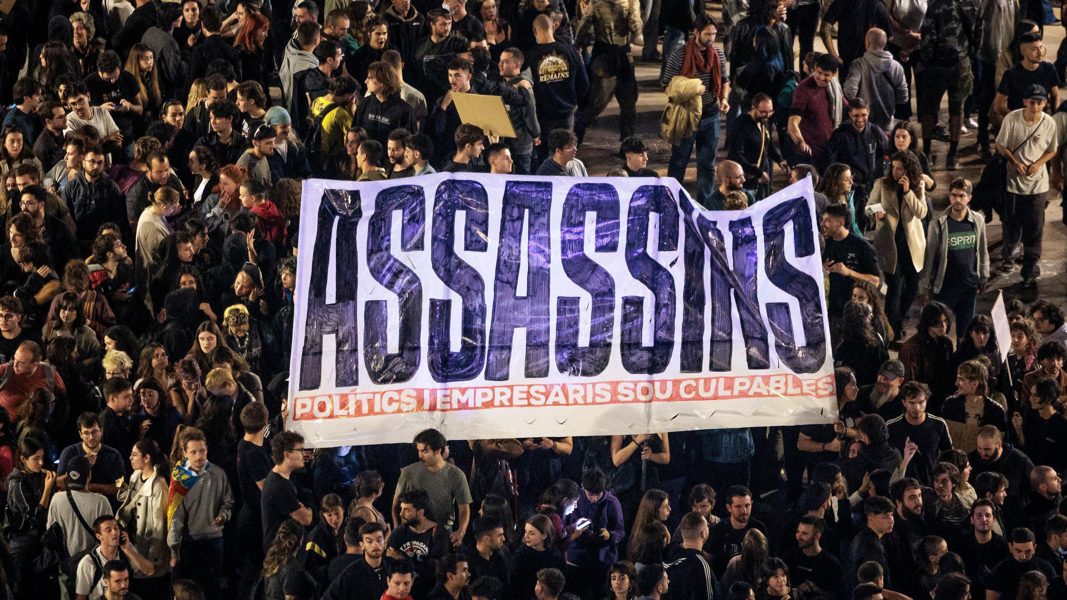 Manifestantes cargan con una pancarta que lee "asesinos. Políticos y empresarios son culpables".