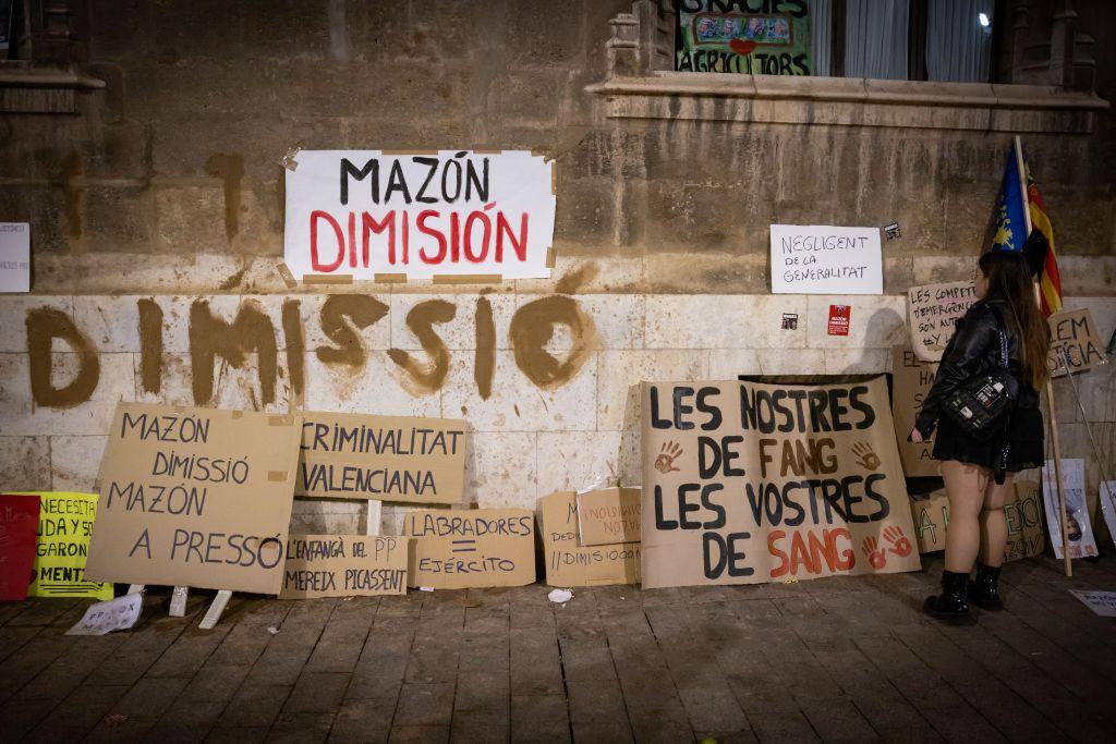 algunas pancartas con diversos mensajes en contra del gobierno. Una de ellas lee "mazón dimisión". 