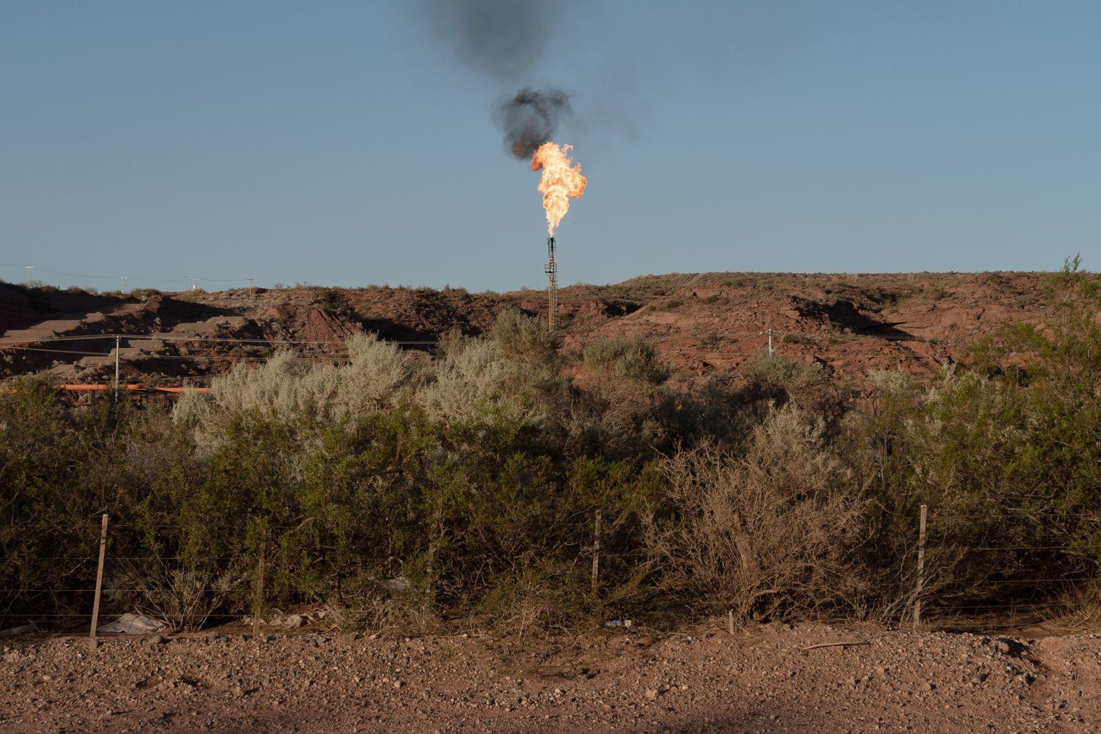 Una chimenea de escape de gas con la llama encendida en Vaca Muerta