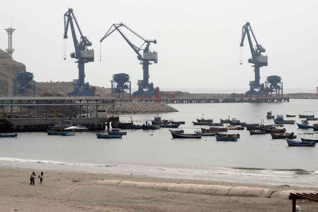 Pequeños barcos pesqueros amarrados en la playa Chancay, con el gran puerto en construcción de fondo. 