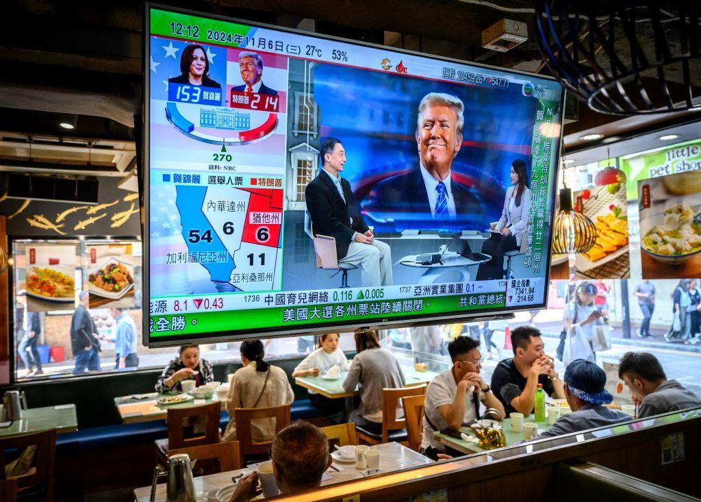 Una pantalla de televisión que muestra los resultados preliminares sobre las elecciones estadounidenses cuelga en un restaurante de Hong Kong el 6 de noviembre de 2024.