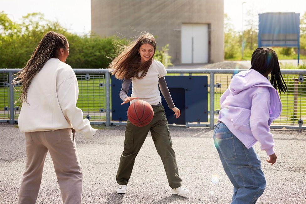 Adolescentes jugando baloncesto