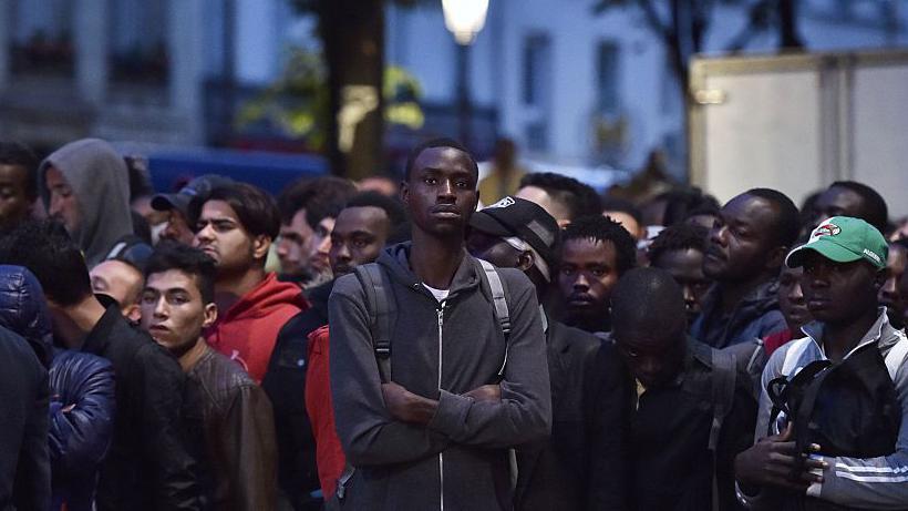 Un grupo de migrantes espera antes de ser evacuado de un campamento improvisado en París, Francia, el 16 de septiembre de 2016.