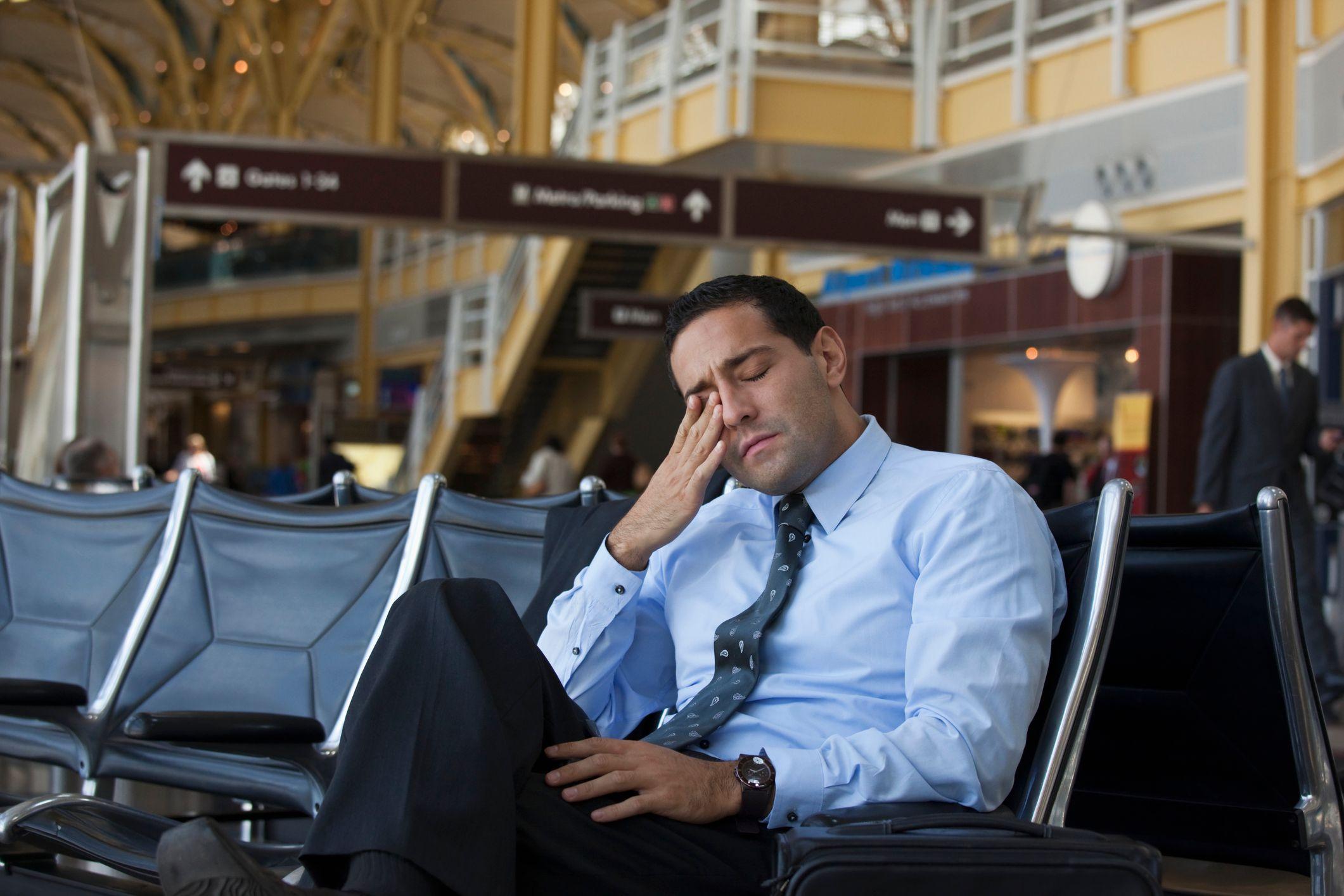 Hombre con jetlag en un aeropuerto