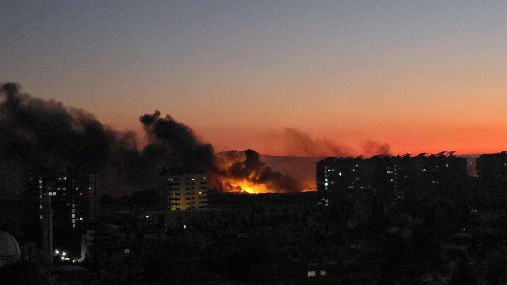 Humo y fuego procedentes de una de las explosiones ocurridas en Damasco tras la entrada en efecto del toque de queda.