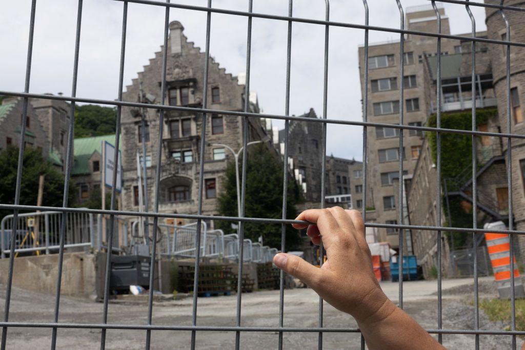 La Madre Mohawk Kwetiio mira a través de una valla en el sitio de construcción del Hospital Royal Victoria el 17 de julio de 2024, en Montreal, Canadá. (Photo by Alexis Aubin / AFP) (Photo by ALEXIS AUBIN/AFP via Getty Images)
