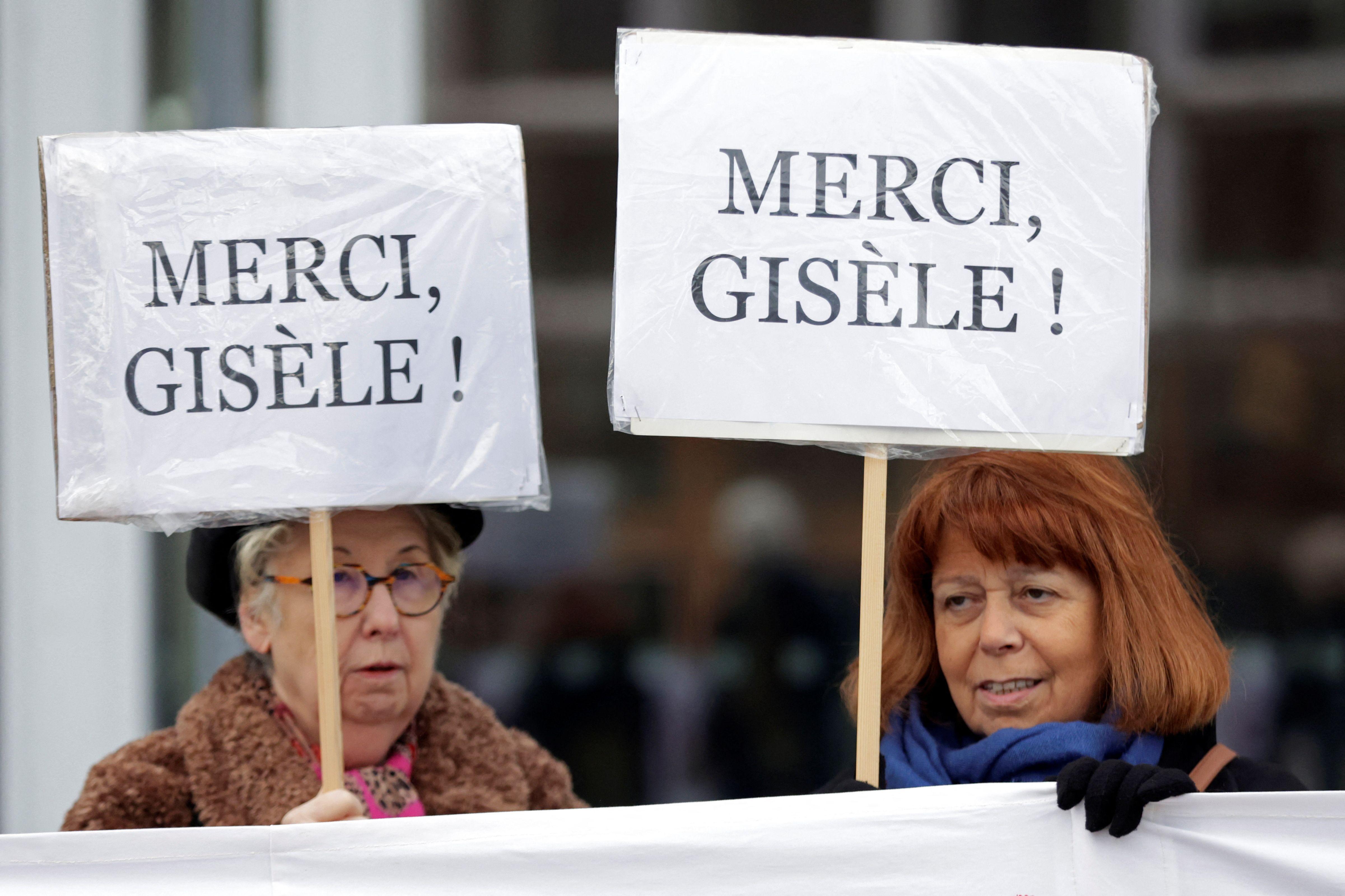 Dos mujeres portan pancartas en las que dan las gracias a Gisèle Pelicot.