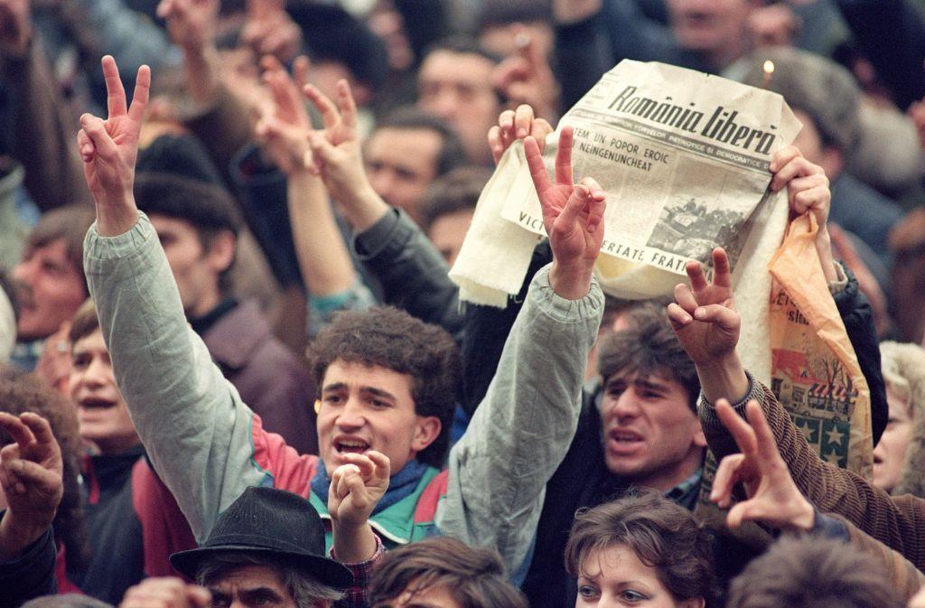 Rumanos en una manifestación en Bucarest, sosteniendo periódicos que anuncian el arresto de Nicolae Ceaucescu el 24 de diciembre de 1989.