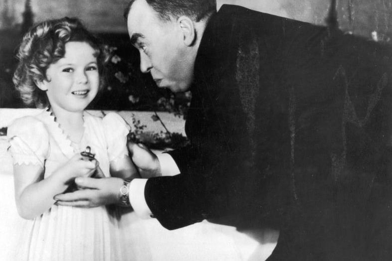 Shirley Temple recibiendo un Oscar especial de manos del guionista estadounidense Irwin S. Cobb en la ceremonia de los Premios de la Academia, en 1935.